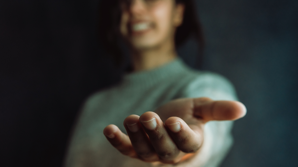 Mujer ofreciendo su mano en señal de ayuda - Más información sobre "Por qué comunicar con empatía es una cuestión de ciencia"
